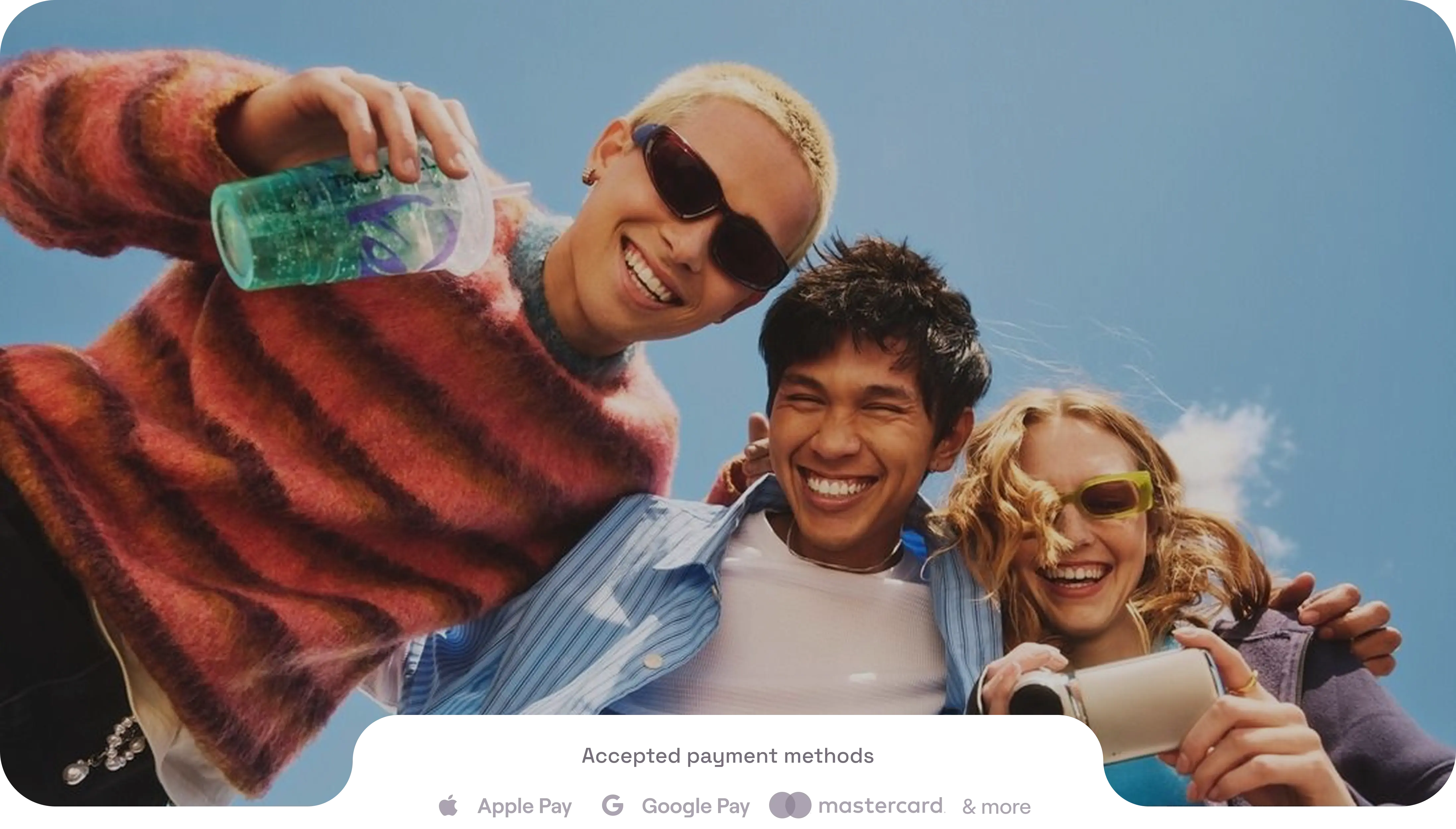 Three friends smiling under a blue sky
