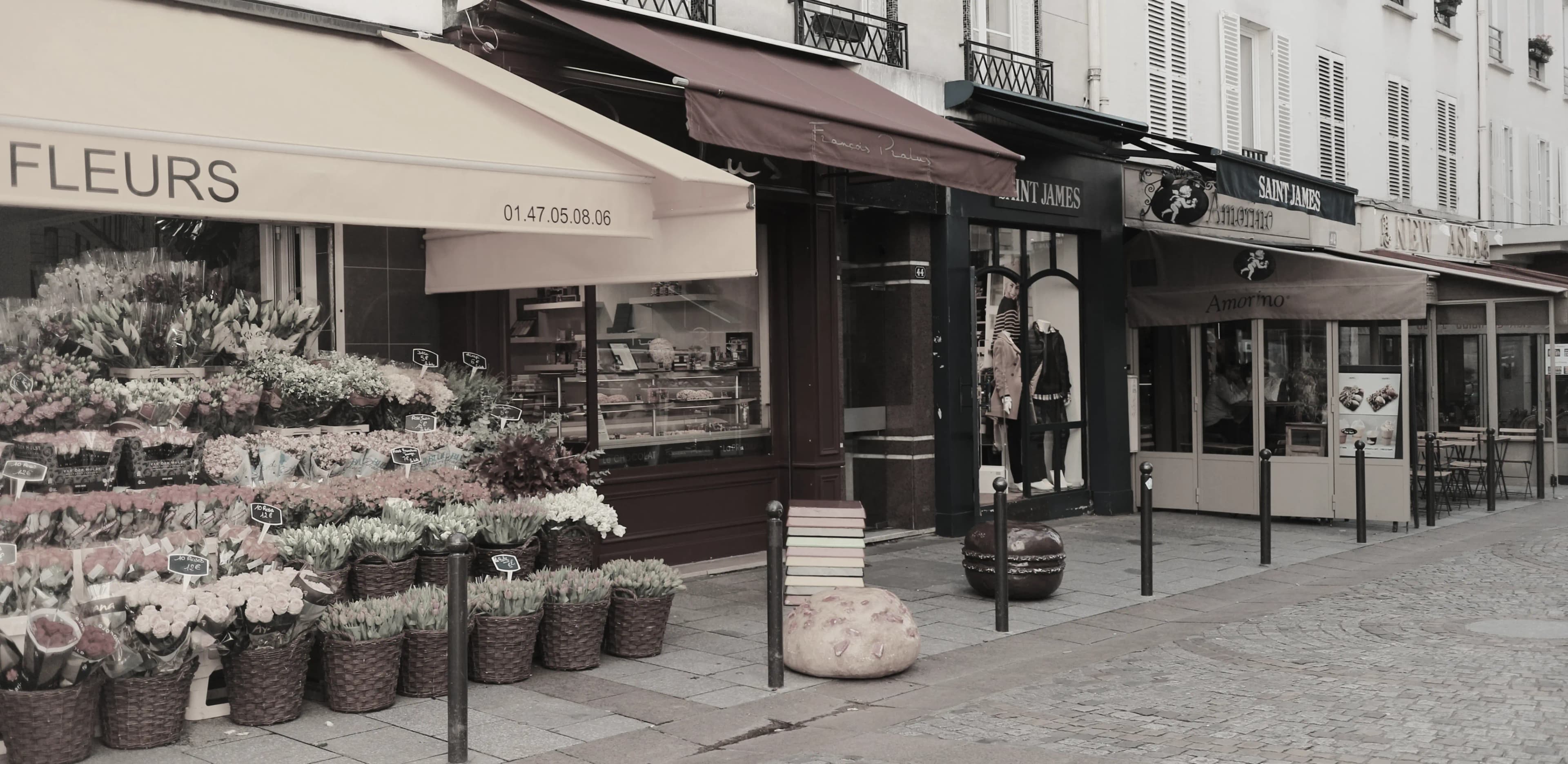 A Parisian street of storefronts — flowers, fashion, cafés